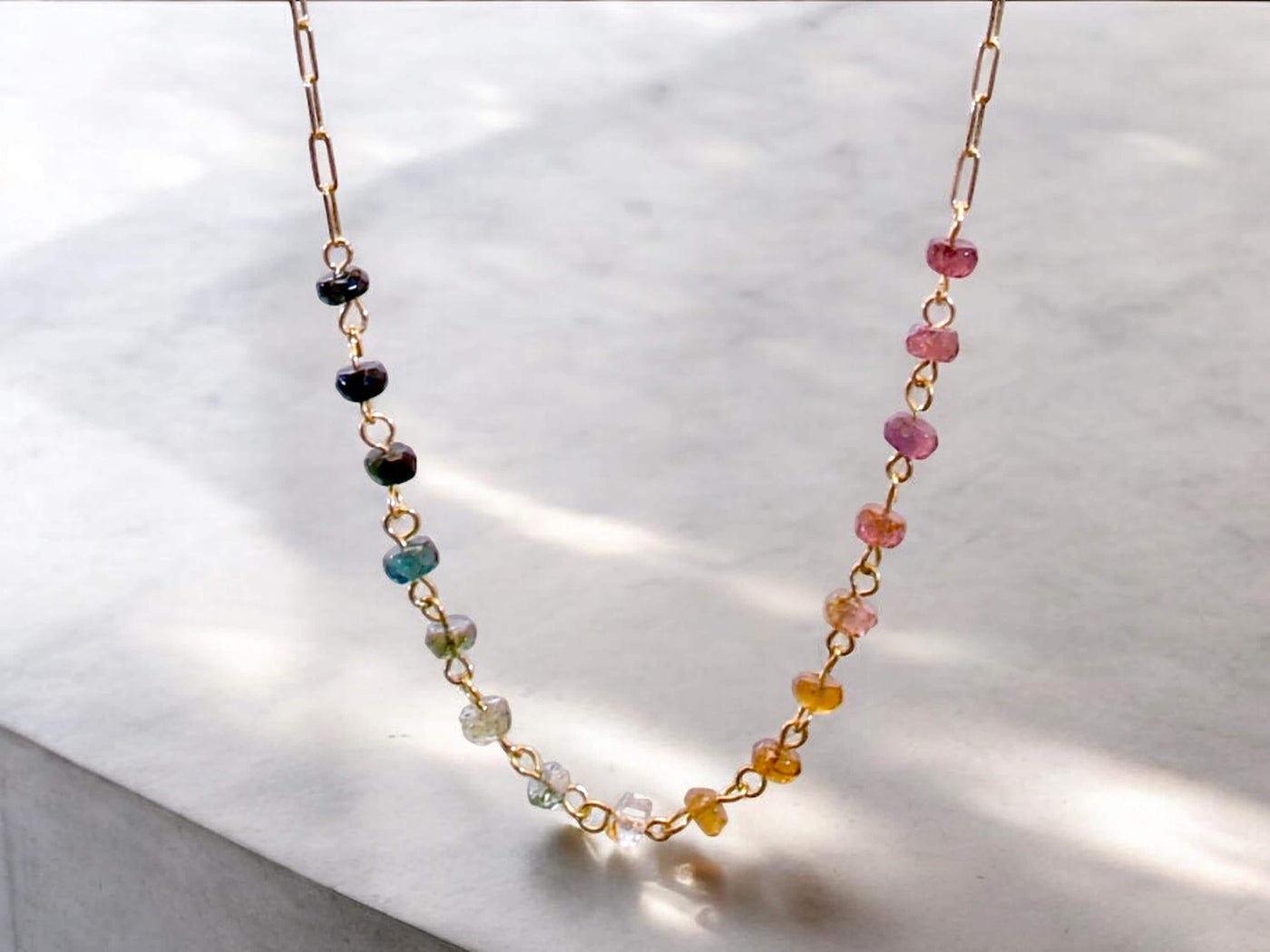 Gorgeous rainbow tourmaline rondelle beaded necklace that is wire wrapped toa 14k gold filled paperclip chain. Handmade and handcrafted natural gems