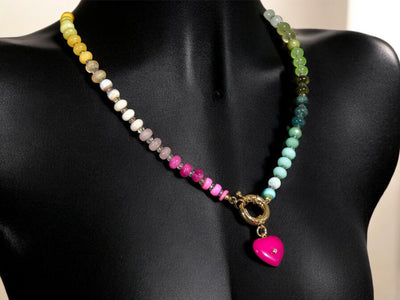 A rainbow multi-gemstone opal necklace that is hand-knotted Made from natural semi precious opal gemstones it features a hot pink heart pendant. It&#39;s feminine & girly w/ a hint of iridescence w/ the added glass shiny beads in between each gemstone.