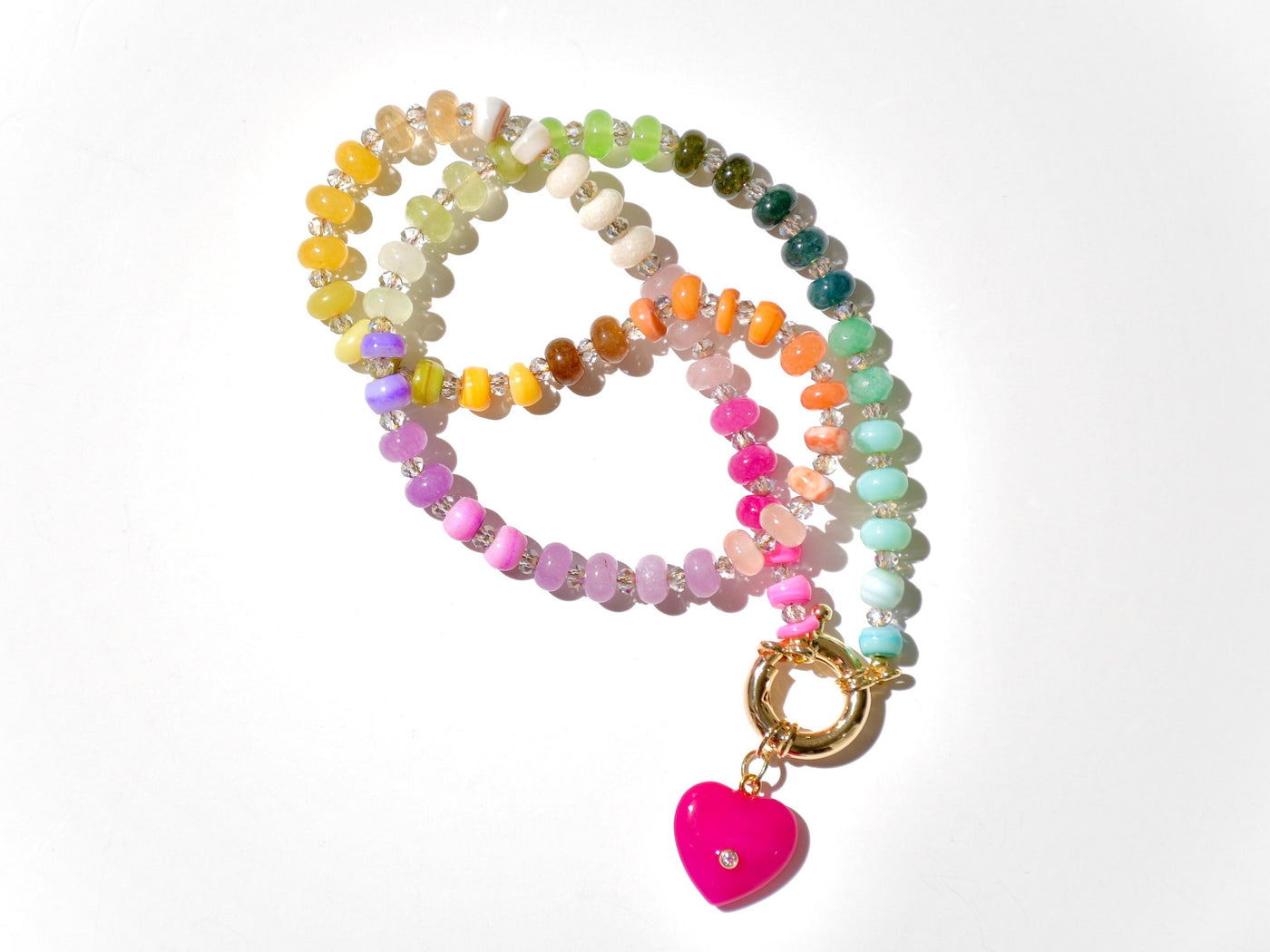 A rainbow multi-gemstone opal necklace that is hand-knotted Made from natural semi precious opal gemstones it features a hot pink heart pendant. It&#39;s feminine & girly w/ a hint of iridescence w/ the added glass shiny beads in between each gemstone.