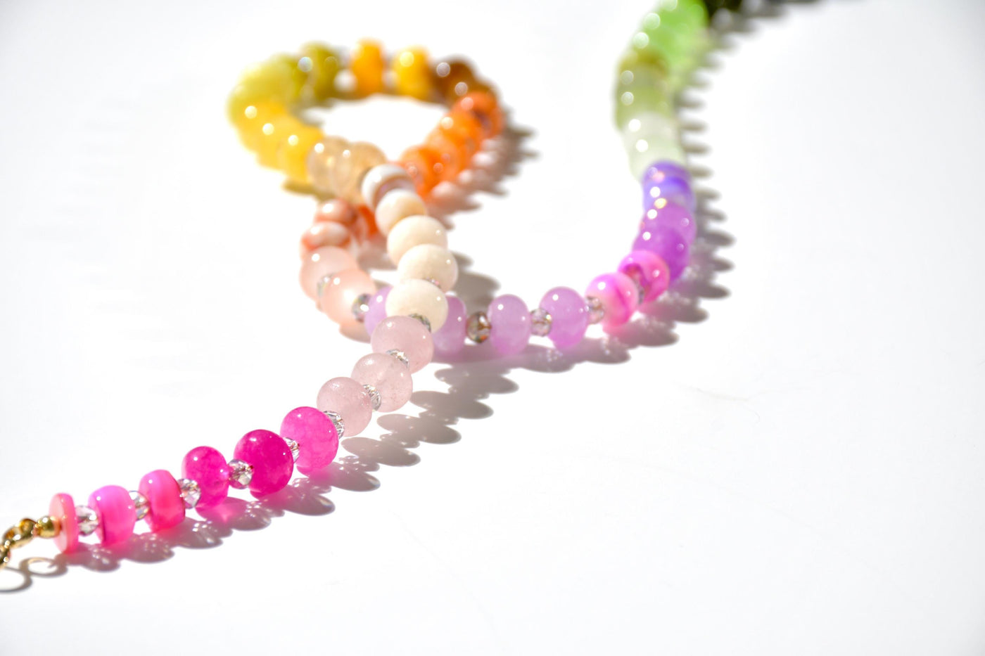 A rainbow multi-gemstone opal necklace that is hand-knotted Made from natural semi precious opal gemstones it features a hot pink heart pendant. It&#39;s feminine & girly w/ a hint of iridescence w/ the added glass shiny beads in between each gemstone.