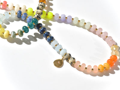 Multi mixed gemstone necklace in earthly jewelry tones. It features gold spacing tube beads that add a hint of shimmer and elegance to the overlook appeal. It has deep oranges, yellows, greens, and browns which tell a vibrant story of a late july.