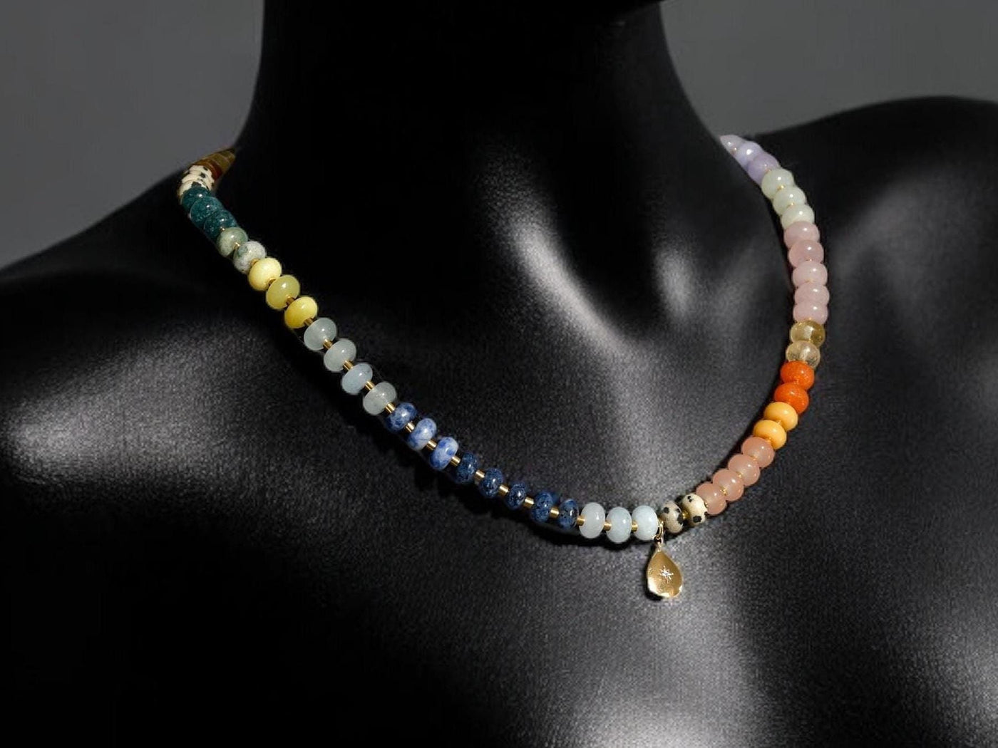 Multi mixed gemstone necklace in earthly jewelry tones. It features gold spacing tube beads that add a hint of shimmer and elegance to the overlook appeal. It has deep oranges, yellows, greens, and browns which tell a vibrant story of a late july.