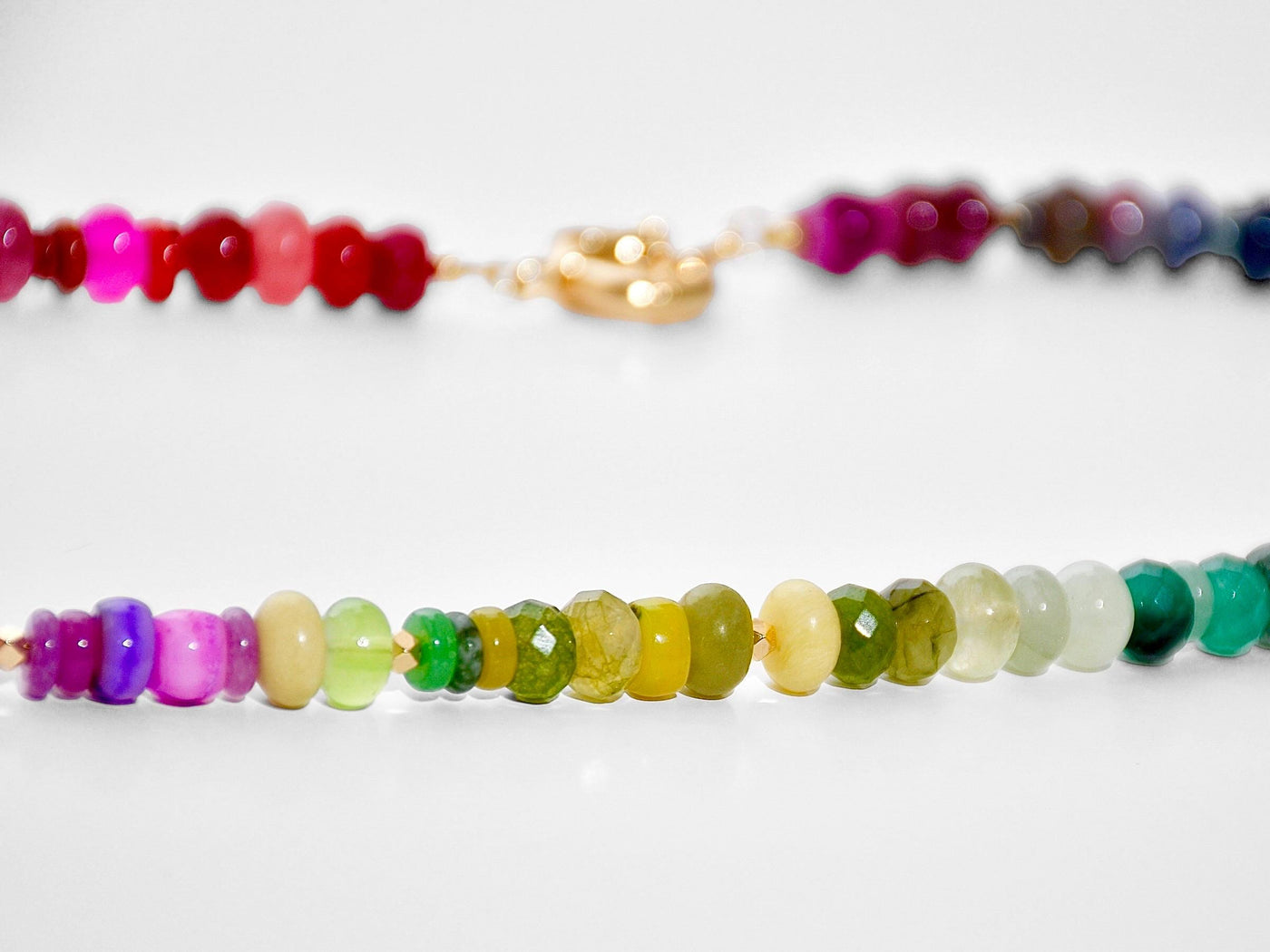 Multi mixed gemstone necklace in bright, jeweled colors . It features gold spacing tube beads that add a hint of shimmer and elegance to the overlook appeal.