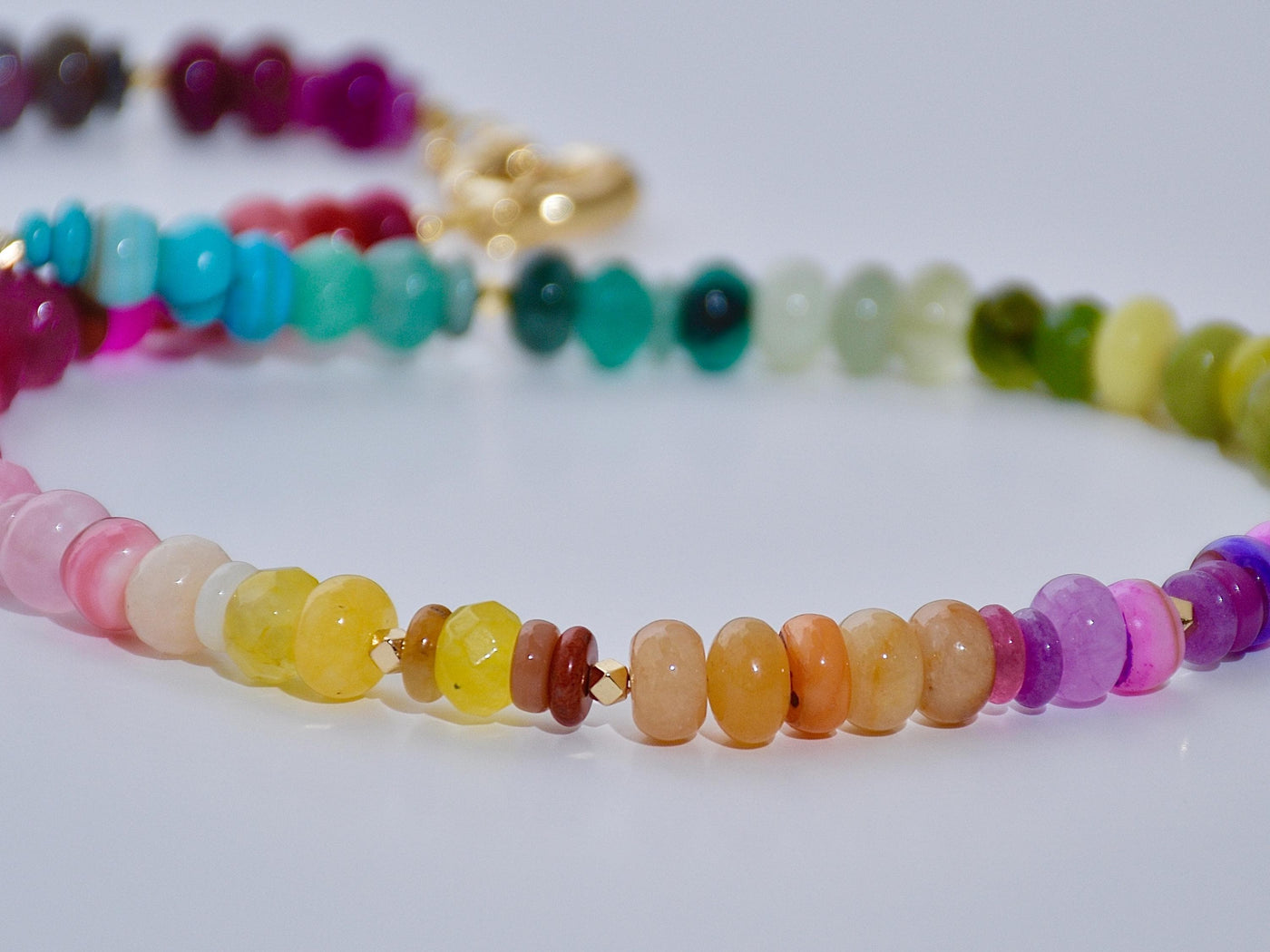 Multi mixed gemstone necklace in bright, jeweled colors . It features gold spacing tube beads that add a hint of shimmer and elegance to the overlook appeal.