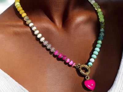 A rainbow multi-gemstone opal necklace that is hand-knotted Made from natural semi precious opal gemstones it features a hot pink heart pendant. It’s feminine & girly w/ a hint of iridescence w/ the added glass shiny beads in between each gemstone.