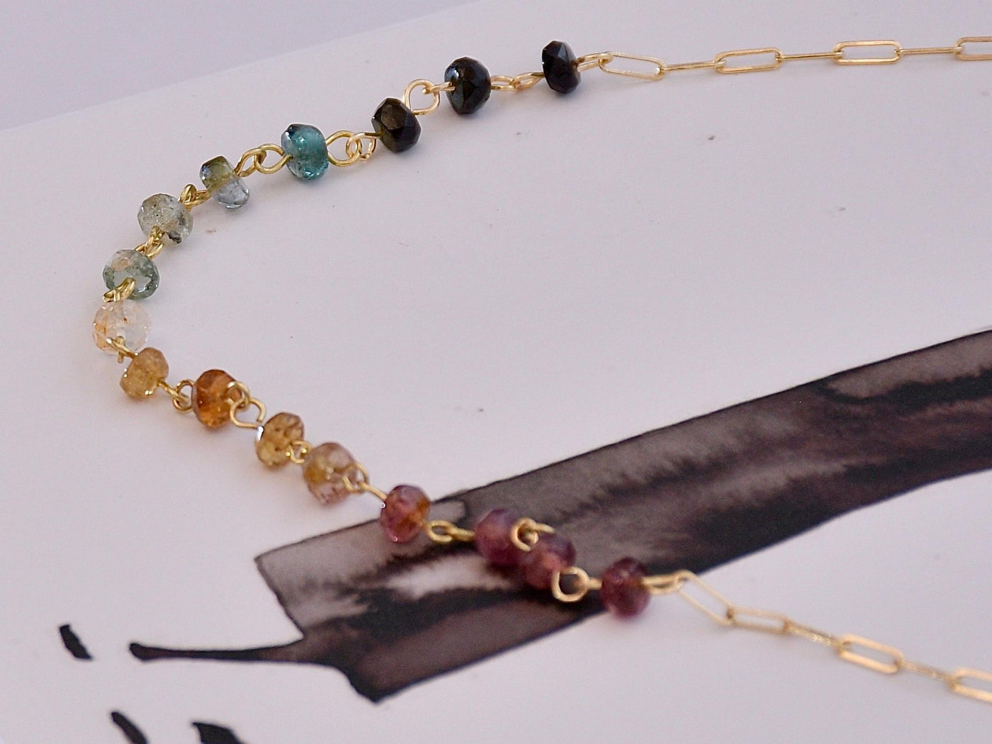 Gorgeous rainbow tourmaline rondelle beaded necklace that is wire wrapped toa 14k gold filled paperclip chain. Handmade and handcrafted natural gems