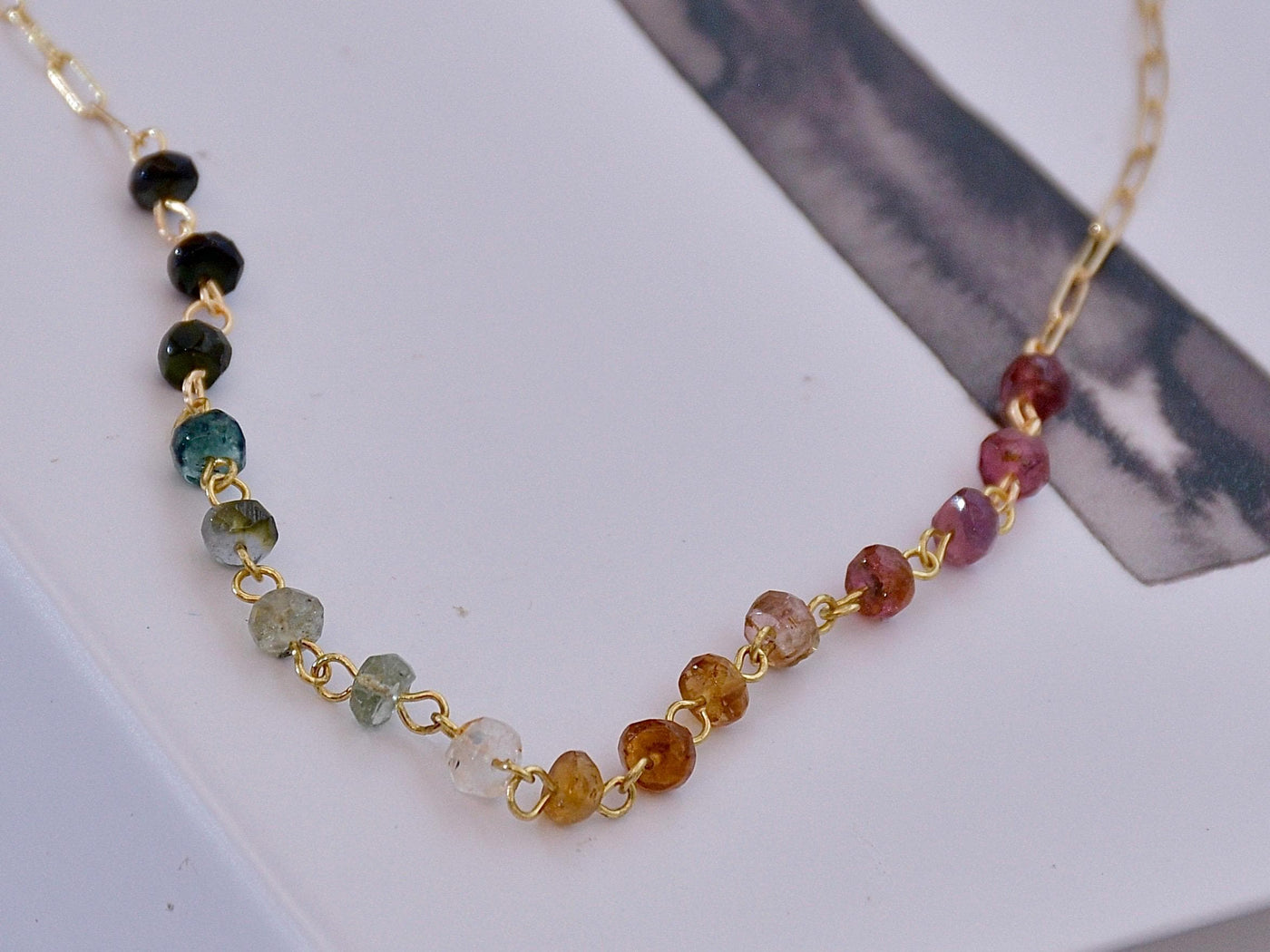 Gorgeous rainbow tourmaline rondelle beaded necklace that is wire wrapped toa 14k gold filled paperclip chain. Handmade and handcrafted natural gems